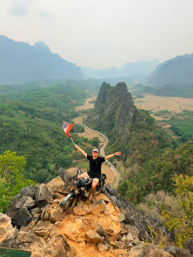 万荣山顶，摩托车上挥老挝国旗